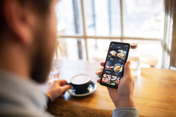 istock Man ordering food delivery on smartphone while enjoying coffee. 1369976767