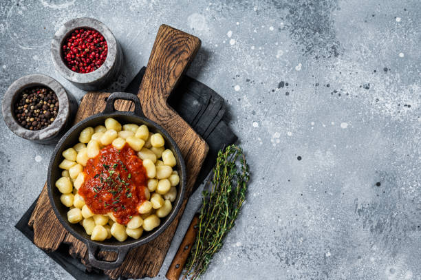 istock Gnocchi pasta with tomato sauce and parmesan. Gray background. Top view. Copy space 1369977568
