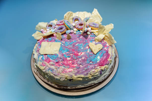 istock Colorful Birthday Cake with Small Donuts and Chocolate Icing 1369977646