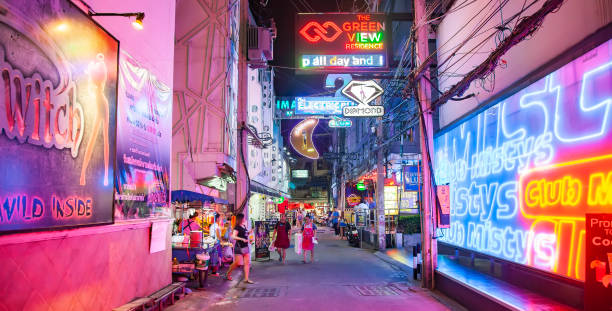 rua neon noturna em pattaya com bares go-go e clubes de strip, tailand - gogo bar - fotografias e filmes do acervo