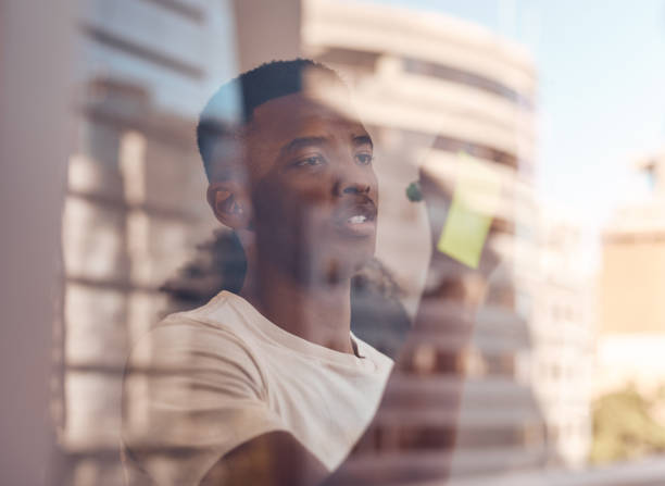 istock Shot of a young businessman brainstorming ideas on sticky notes 1369979455
