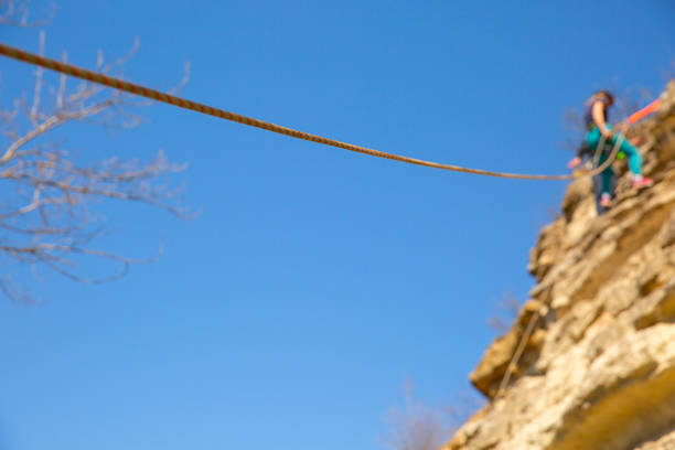 View on rope security system attached to the rock in the mountain. People visible in the background