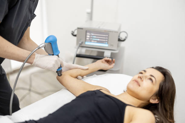 istock Doctor applies shock wave therapy on women's knee 1369983829