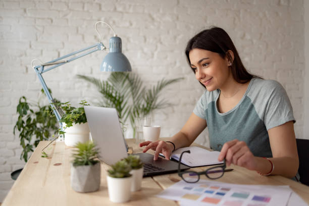 istock Successful Caucasian woman working from home using a laptop 1369984151