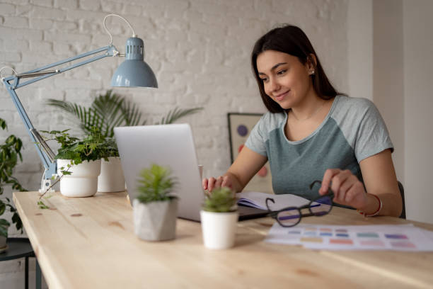 istock Successful Caucasian woman working from home using a laptop 1369984208