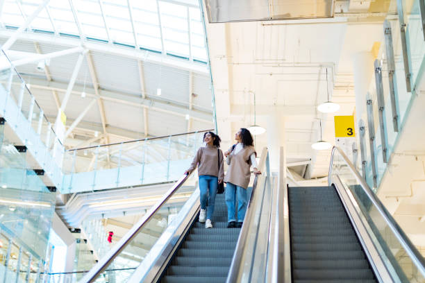 istock Two woman on escalator in shopping mall 1369985785