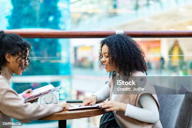 Two African Women In Shopping Mall Stock Photo - Download Image Now - Menu, Shopping Mall, Dinner