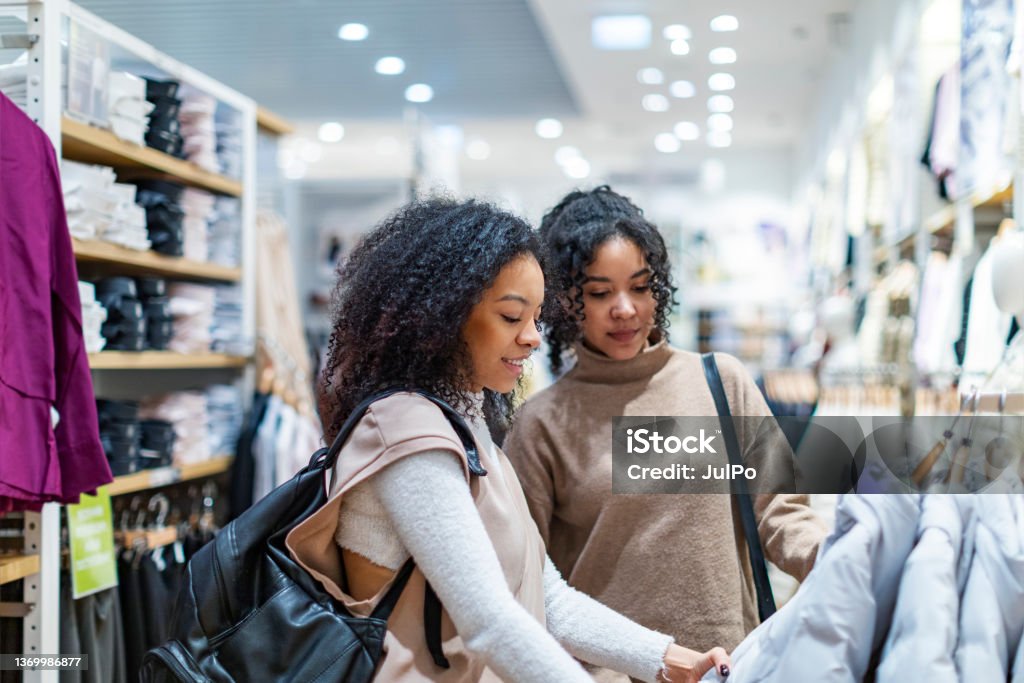 Two women trying on clothes in shopping mall Two woman in shopping mall Retail Stock Photo