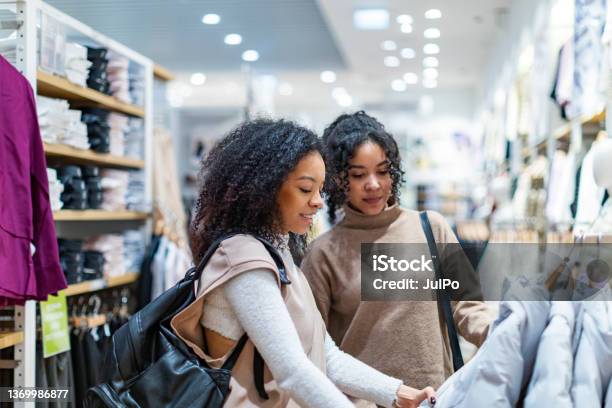 Two Women Trying On Clothes In Shopping Mall Stock Photo - Download Image Now - Retail, Clothing Store, Shopping