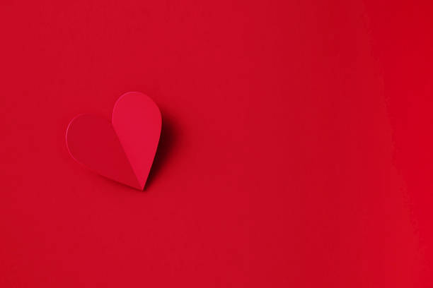 istock Valentine's Day Concept - Folding Red Heart Shape Over Red Background 1369988984