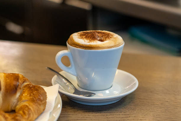 コーヒーショップでの朝食にカプチーノカップとクロワッサン - モカ ストックフォトと画像