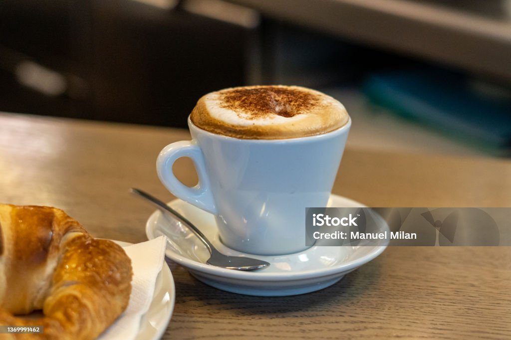 Cappuccino cup and croissant for breakfast in a coffee shop Cafe Stock Photo