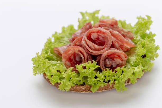 Sandwich with salami sausage on white background.