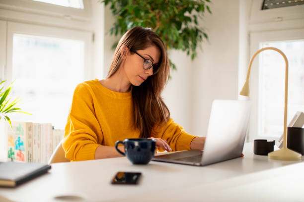 istock Beautiful young woman working at home 1369992700