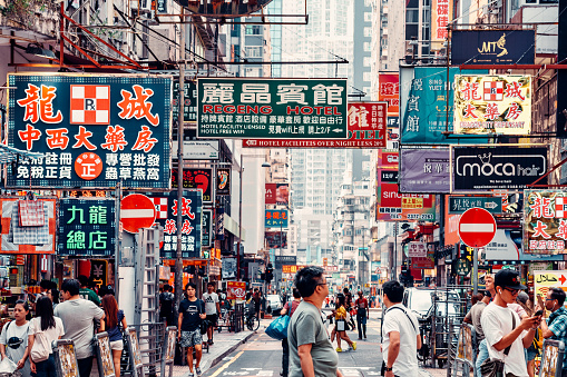 Street scene with people and neon signs in Knowloon, Hong Kong