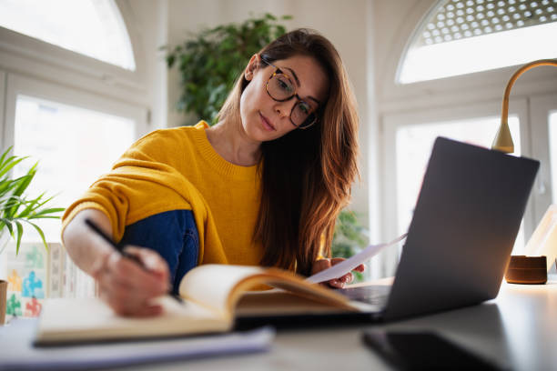 istock Beautiful young woman working at home 1369993785