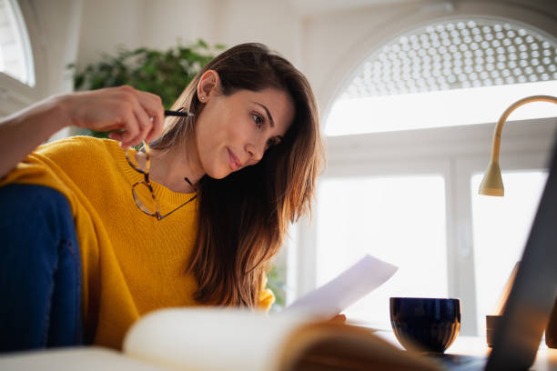 istock Beautiful young woman working at home 1369993816