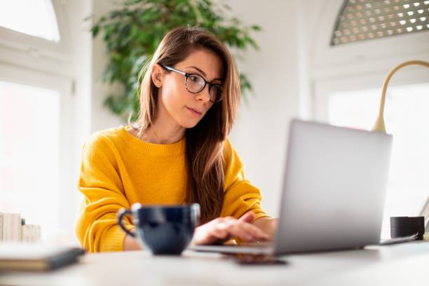 istock Beautiful young woman working at home 1369996550
