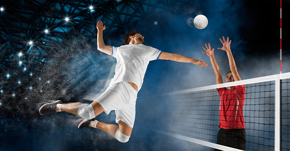 Female volleyball players kicking ball through net and jumping high during sports competition