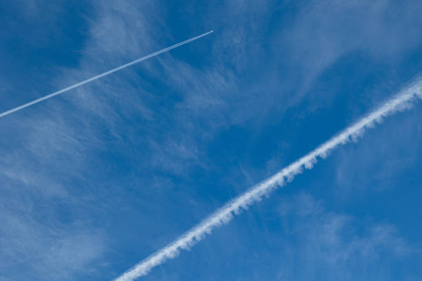 Close up extreme low angle view of condensation trails and little very thin clouds in the sky.