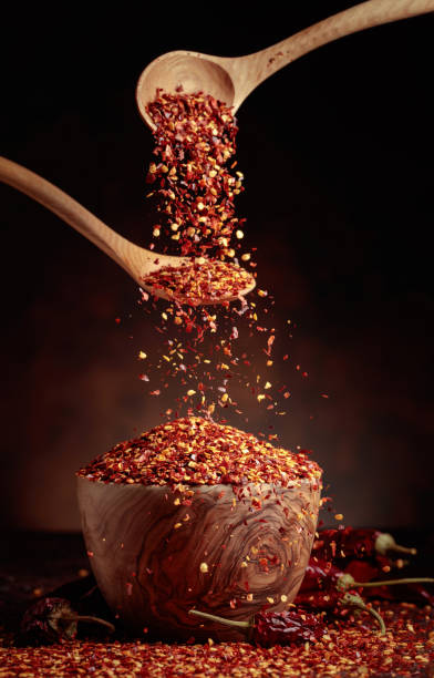 istock Chilli flakes are poured into a wooden dish. 1369999771