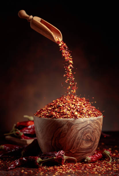 istock Chilli flakes are poured into a wooden dish. 1369999773