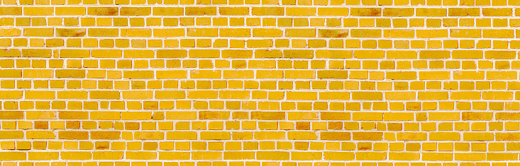 Weathered texture of painted old yellow brick wall background, rough rusty masonry technology blocks, colorful horizontal architecture
