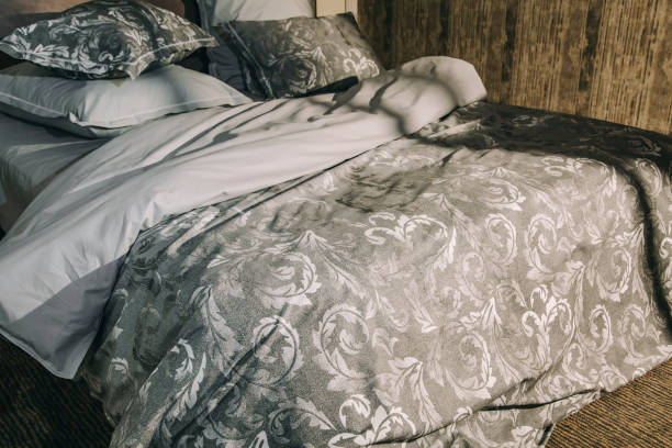 istock Modern luxurious soft bed with grey shades and creative pattern, morning sunbeam in bedroom 1370002386