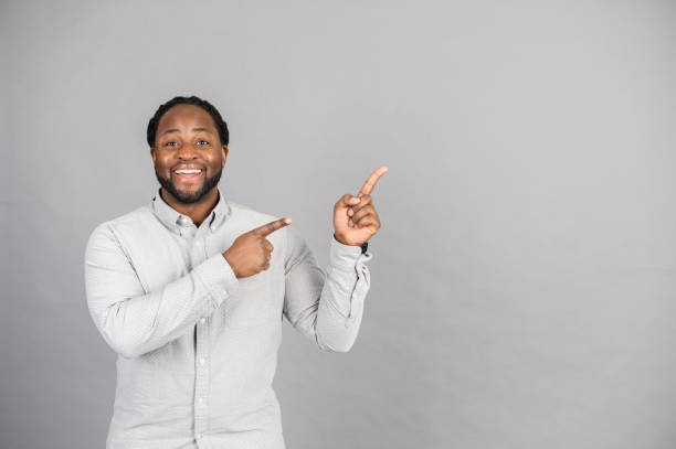 istock African-American man points finger up isolated on grey 1370005225