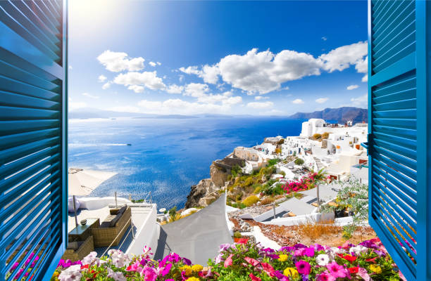 window view past shutters from a luxury resort terrace overlooking the sea, caldera and whitewashed village town of oia, on the greek island of santorini, greece. - sky sea town looking at view imagens e fotografias de stock