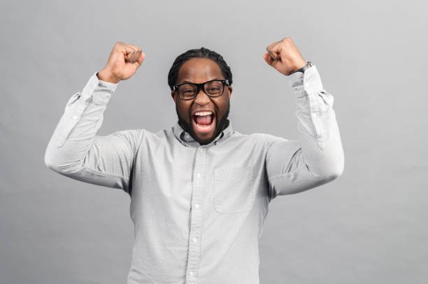istock Cheerful African-American man screaming happily, isolated on grey 1370005662