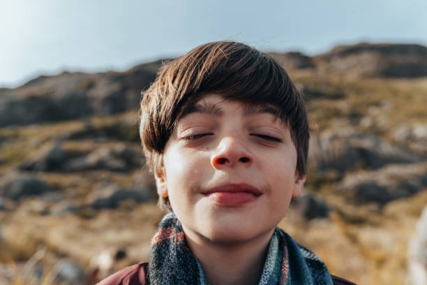 Smiling boy taking a deep breath in the national park