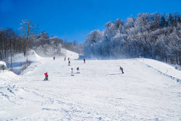 Ski resort in the mountains. gente haciendo snowboard cuesta abajo en las pistas de esquí. gente esquiando y practicando snowboard freestyle en la estación de esquí. actividades de ocio de deportes de invierno. concepto de deportes extremos. concepto de actividades de nieve.