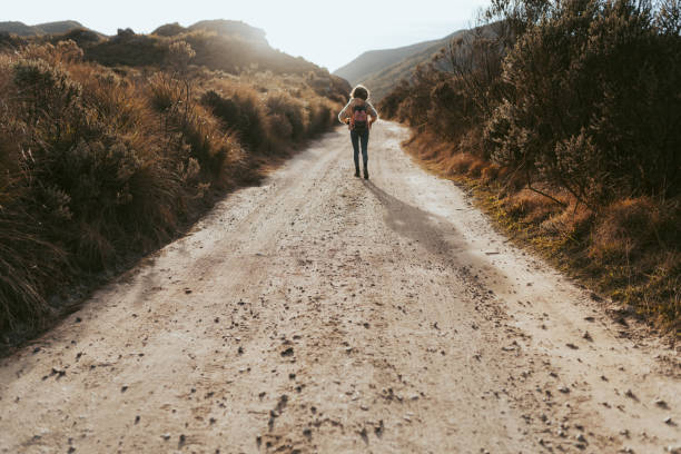 istock Backpacker walking on the road in the desert 1370007299