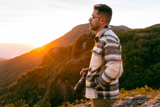 istock Photographer enjoying sunset in the mountains 1370007588