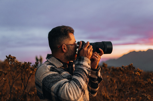 Professional photographer in the mountains at sunset
