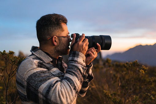 Professional photographer in the mountains at sunset