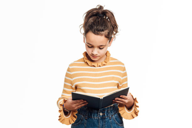 istock Young girl reading a book while standing on an isolated white background. 1370009547