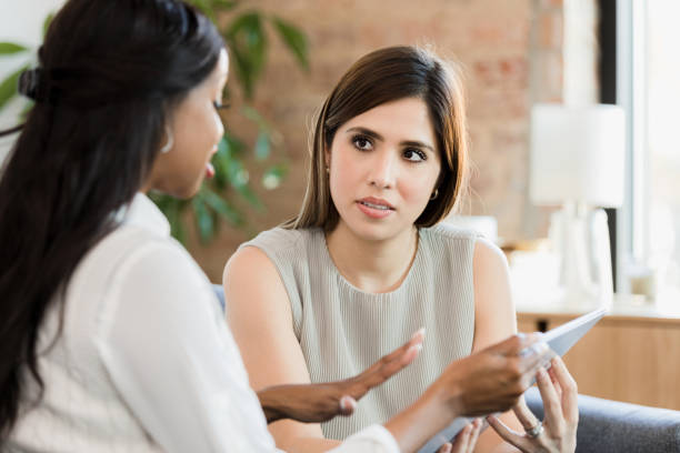istock Woman listens as female counselor explains app on tablet 1370014523