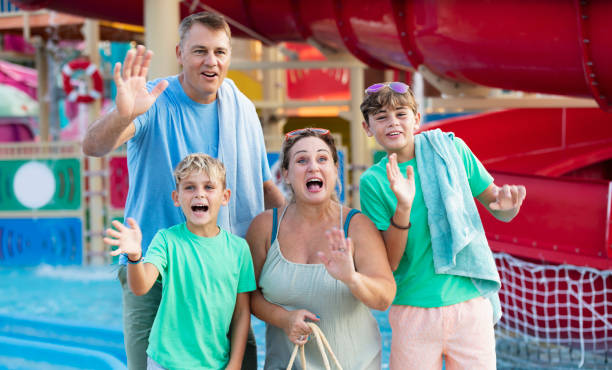istock Family with two boys waving at water park 1370014838