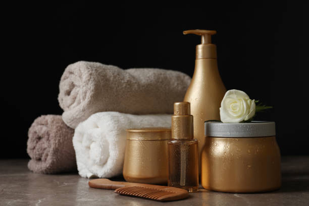 istock Different hair products, rolled towels and comb on grey table 1370015493