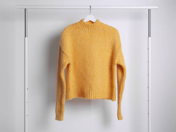 istock Warm sweater hanging on rack against white background 1370015554