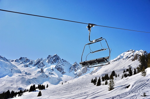 Chair lift over snowcapped mountains