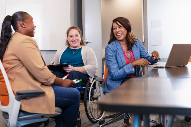 woman in wheelchair, coworkers having business meeting - 社會包容 圖片 個照片及圖片檔