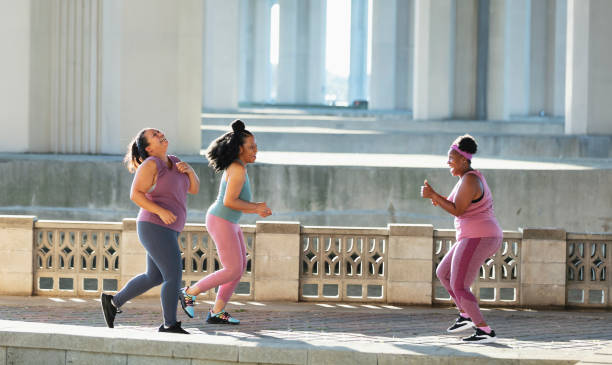 istock Women running on city waterfront, run into friend 1370016177