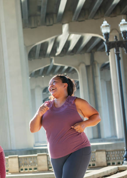 istock Pacific Islander woman running under city bridge 1370016921