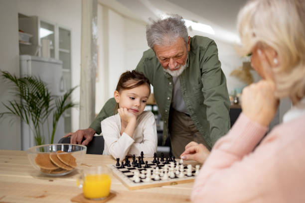 istock Grandparents teaching a granddaughter how to play chess 1370020904