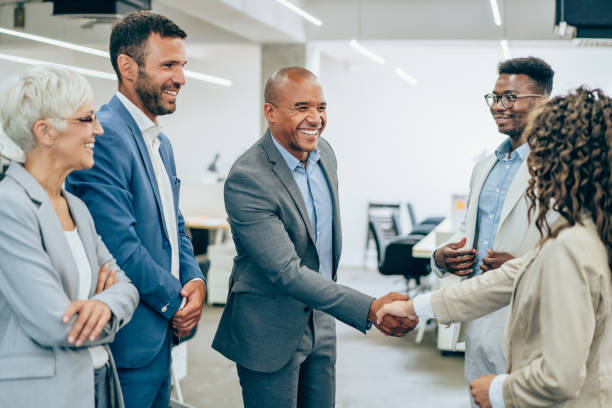 Successful partnership Business people shaking hands in the office. Business persons handshaking during a meeting in modern office. new hire stock pictures, royalty-free photos & images