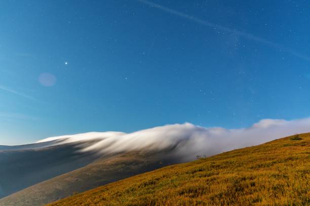 istock Thick fog covering mountain hills at bright night 1370022467
