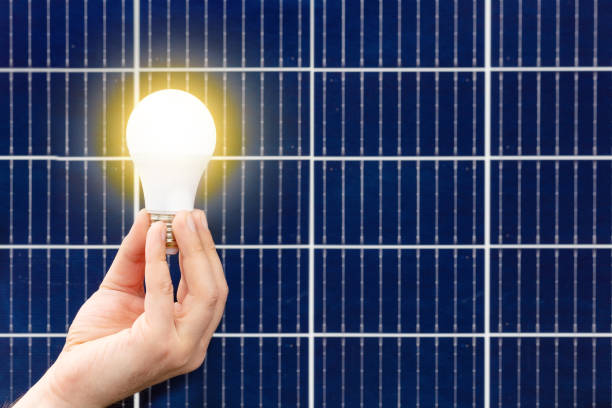 istock Hand holding light bulb against solar panel, solar station. Idea concept of alternative energy, technology, environment, ecology. Green power energy. 1370022774
